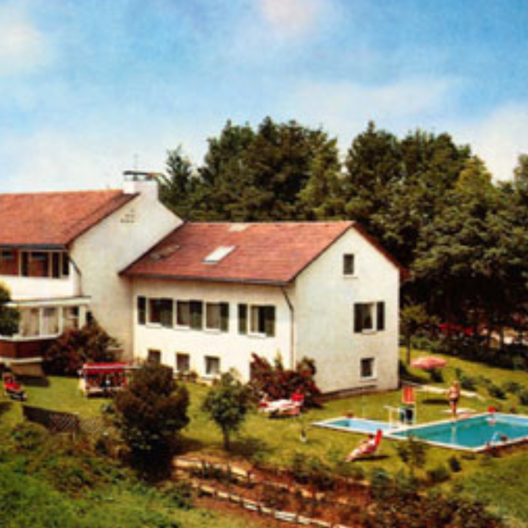 Zwei Frauen lächeln mit Weinglas der Hand.