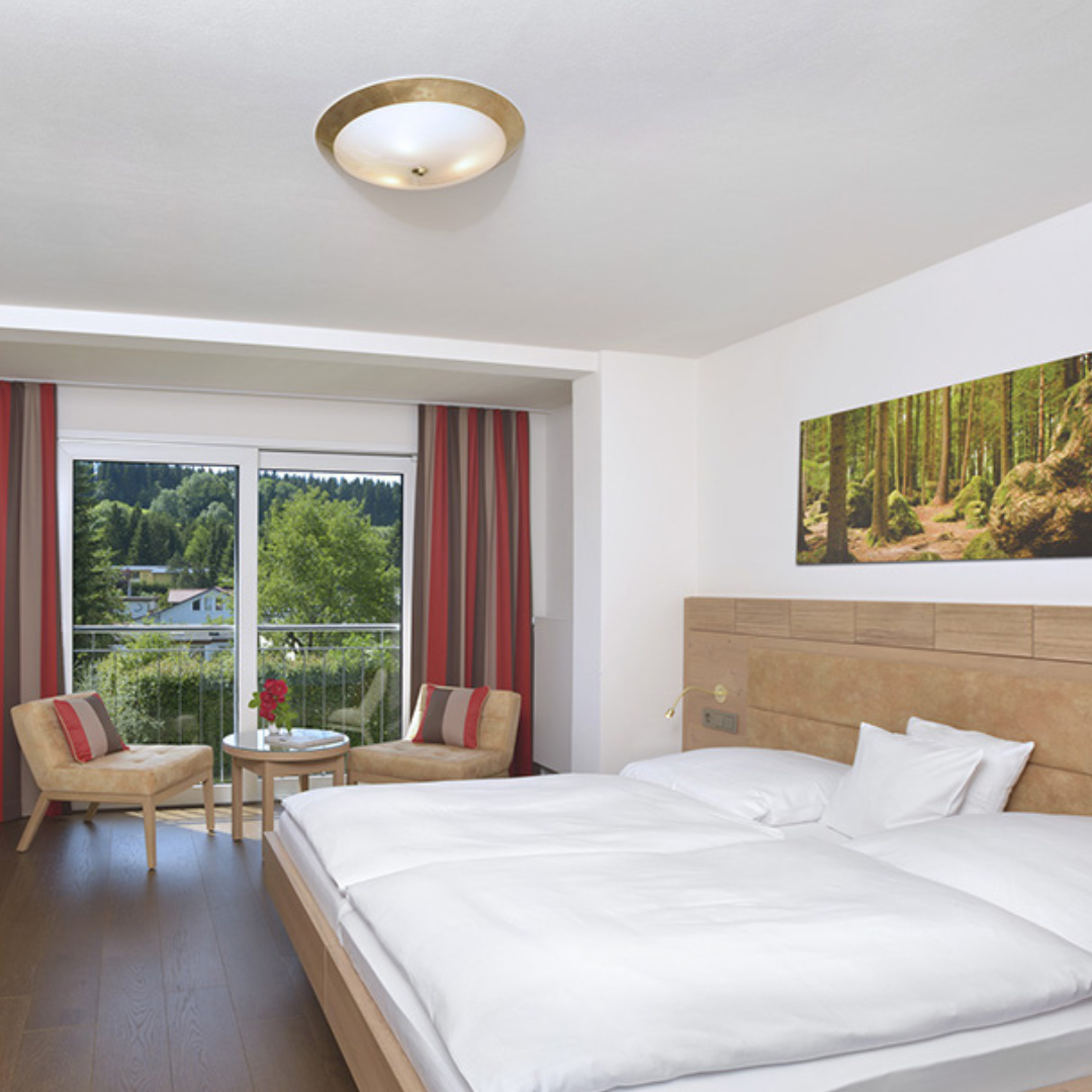 Zwei Frauen lächeln mit Weinglas der Hand.